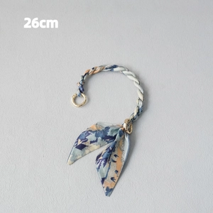Detail of 26cm scarf-wrapped handbag handle with blue and orange floral silk bow accents