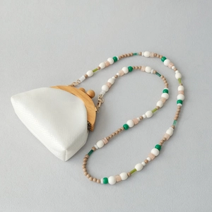 Détail du mini sac blanc texturé avec cadre en bois et bandoulière en perles colorées