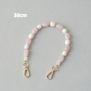 Vue détaillée d'une chaîne de perles en acrylique de 38cm avec des fermoirs dorés chic