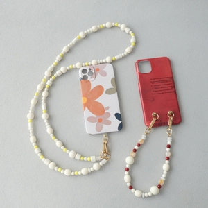 Détails de coque fleurie et intérieur rouge avec lanières en perles et fermoirs en métal