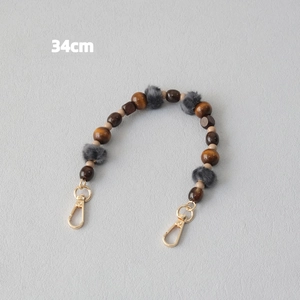 Detail of 34cm wooden bead chain with grey faux fur balls and golden lobster clasps