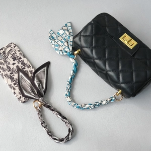 Quilted leather handbag with silk scarf strap and floral phone case accessory set