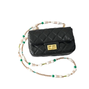 Sac à main en cuir matelassé noir avec chaîne en perles acryliques et fermoir doré