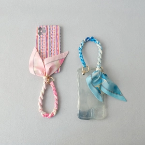 Chic phone cases with geometric patterns and silk scarf wrist chains for a stylish look
