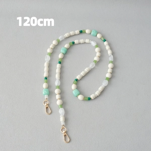Détail d'une chaîne en perles acryliques de 120 cm avec perles vert menthe et blanc crème