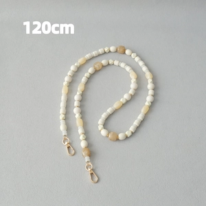 Détail chaîne en perles acryliques de 120cm avec perles ambre et crème et fermoirs dorés