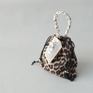 Detailed macro shot of a leopard print drawstring bag with a woven patterned handle