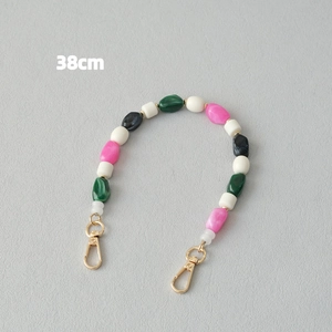 Détail d'une chaîne de perles en résine colorée de 38cm avec fermoirs mousquetons dorés
