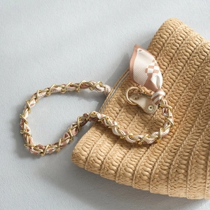 Sac à bandoulière en paille tissé avec chaîne dorée et détail de foulard en soie