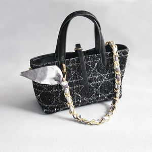 Détail du sac en tweed avec surpiqûres cannage et bandoulière chaîne dorée