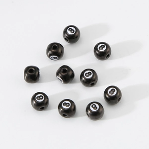Detalle macro de cuentas de bola de billar negra número 8 de acero para joyería artesanal
