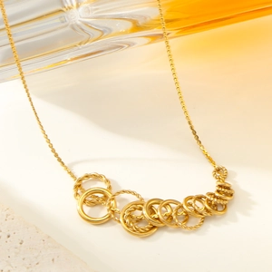 Collier élégant avec connecteurs à anneaux torsadés dorés et pendentif géométrique