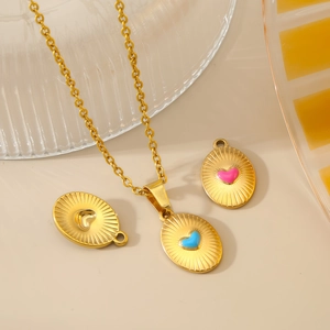 Gold stainless steel necklace featuring a sunburst oval pendant with pink heart inlay