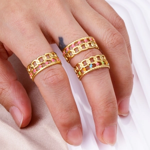 Détail d'une bague chaîne gourmette dorée avec émail en étoile colorée sur la main