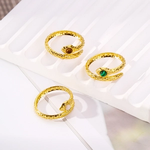 Detailed view of three gold snake rings with colorful stone inlays and scale texture