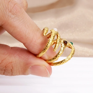 Minimalist gold snake ring with malachite eyes and detailed scale texture