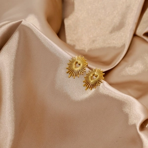Detailansicht der 18k vergoldeten Herz-Ohrstecker auf elegantem Champagner-Satin-Stoff