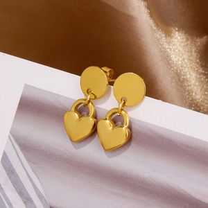 Gros plan détaillé de boucles d'oreilles cœur dorées sur fond de satin champagne