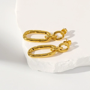 Detailed close-up of double-loop gold earrings with textured lava finish on stone