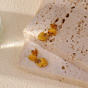 Vue détaillée des boucles d'oreilles cœur dorées 18k mates sur pierre naturelle