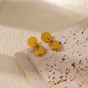 Vue détaillée de boucles d'oreilles cœur en or mat 18 carats sur support en pierre