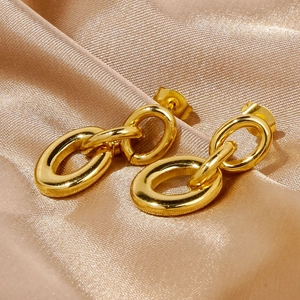 Detailed macro shot of gold-plated triple interlocking hoop earrings on satin