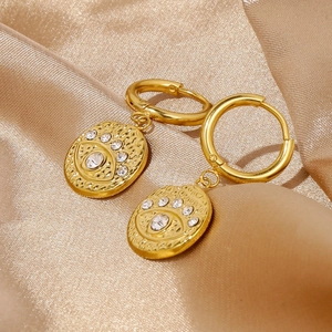 Detail of 18k gold hammer textured evil eye earrings with zircon on satin