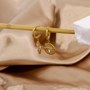 Detail of 18k gold stainless steel evil eye earrings with zircon on bamboo stand