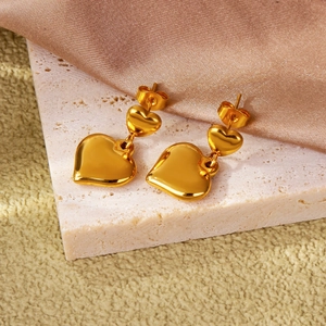 Boucles d'oreilles minimalistes à double cœur doré sur fond de pierre et soie