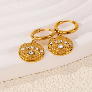 Detail of 18k gold evil eye earrings with hammered texture and cubic zirconia inlay