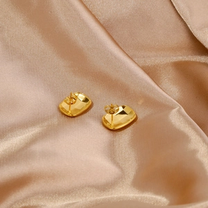 Detail view of gold square stud earrings showing back post and butterfly closure on satin
