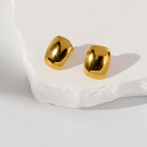 Detailed view of minimalist gold polished cushion square stud earrings on white stone