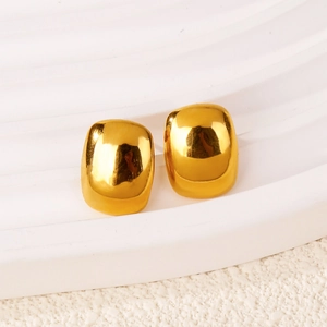 Macro detail of high-polish gold minimalist square stud earrings on a display