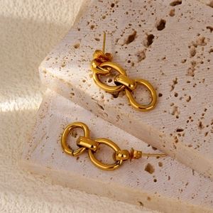 Détail des boucles d'oreilles doubles cercles dorés sur support en pierre beige