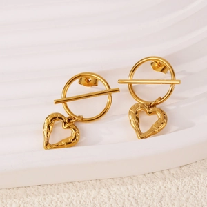 French style gold hollow heart drop earrings with lava texture on white wavy display stand
