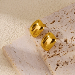 Detail view of 18K gold plated polished rectangular stud earrings on a stone surface