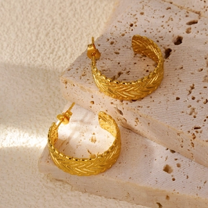 18k gold-plated C-shaped hoop earrings with woven texture on travertine stone