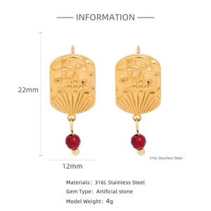 Detailed view of 18k gold stainless steel earrings with red ruby charms and star engraving