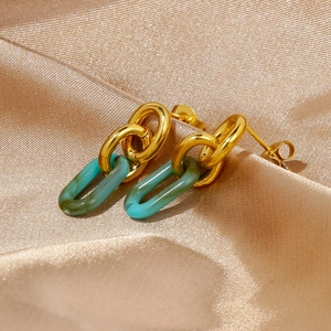 Détail de boucles d'oreilles géométriques en acrylique plaqué or 18k sur soie