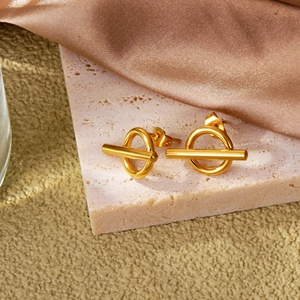 Minimalist gold geometric hoop earrings with bar accent on elegant marble background