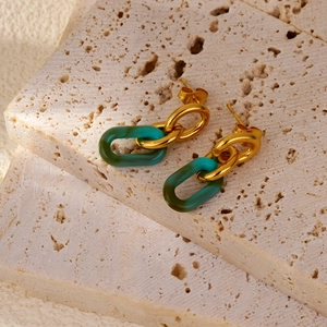Détail de boucles d'oreilles géométriques en or 18k et résine acrylique vert foncé