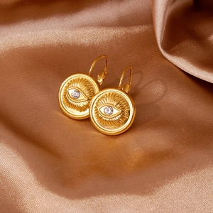 Vue détaillée des boucles d'oreilles Œil d'Oeil en or 18k avec zircon sur fond de soie
