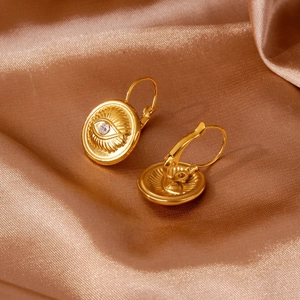 Vue macro de boucles d'oreilles œil porte-bonheur en or 18k avec zircon sur soie bronze luxe