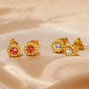 Close-up of sunflower earrings with red and clear zircon set in 18k gold-plated steel