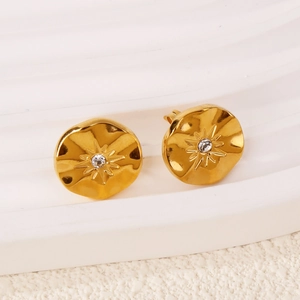 Vue macro de boucles d'oreilles tournesol en or 18k avec finition mate et zircon central