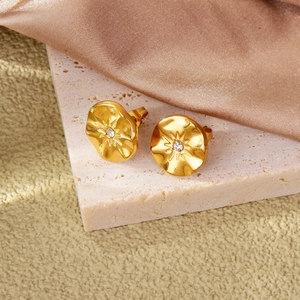 Détail des boucles d'oreilles soleil plaquées or 18k sur soie champagne et pierre