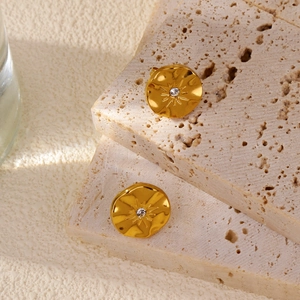 Détail macro des boucles d'oreilles tournesol irrégulières dorées 18k avec cristal étoile