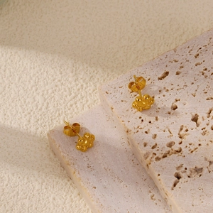Dettaglio di orecchini a lobo a forma di girasole in oro 18k su supporti in pietra