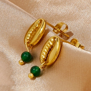 Detailed close-up of 18k gold-plated shell earrings with green stone on champagne silk