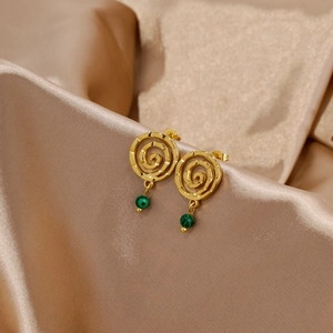Macro detail of 18k gold spiral earrings with malachite green stone on silk
